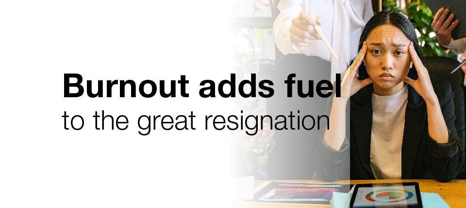 A woman sitting at a desk looking stressed out because of burnout